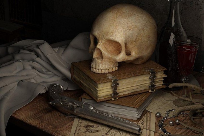 A skull, books, a quill, and a glass of red liquid on a wooden table. 3