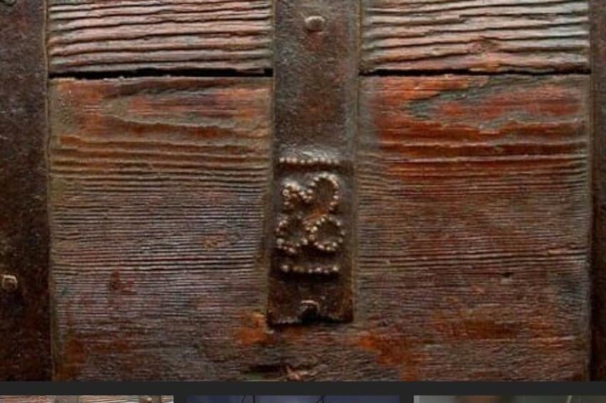 A weathered wooden surface with horizontal planks and a central metal bracket with a decorative emblem. 3