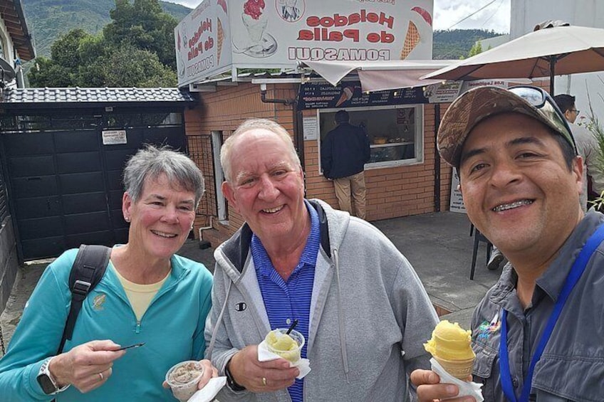 Three people eating ice cream cones in front of an ice cream shop. 2