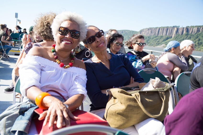 A group of people on a boat with cliffs in the background. 5