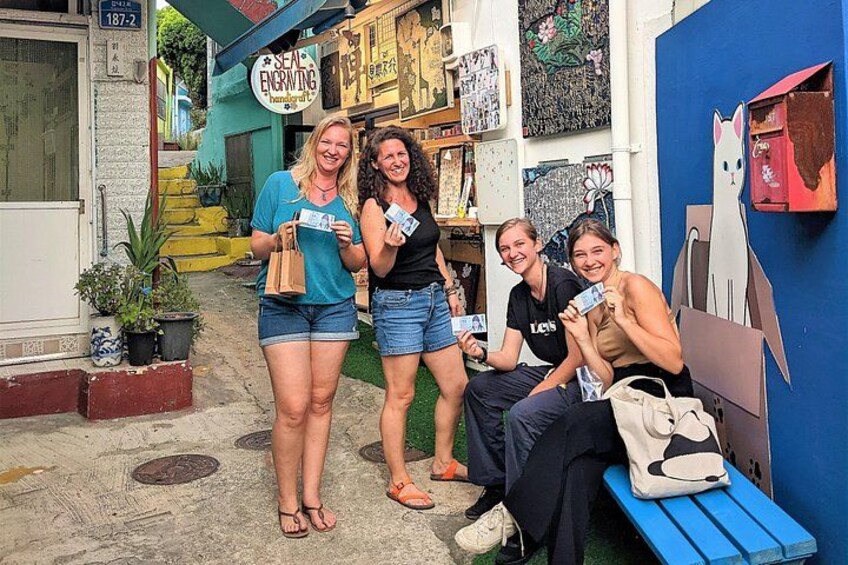 Un grupo de personas en un entorno exterior colorido, con una tienda al fondo. 2