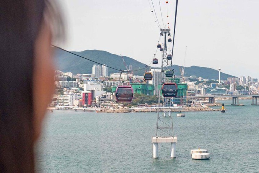 A cable car system over water with a cityscape in the background. 2