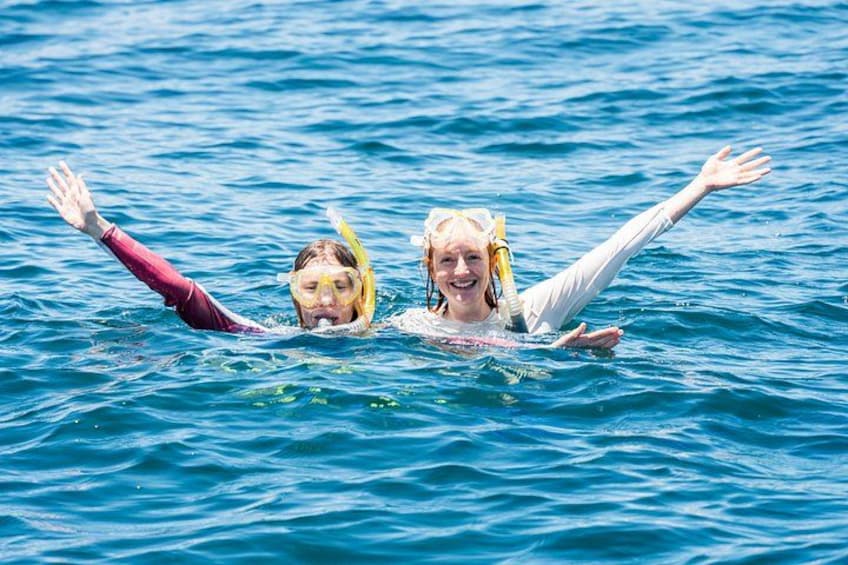Two people swimming in the ocean. 4