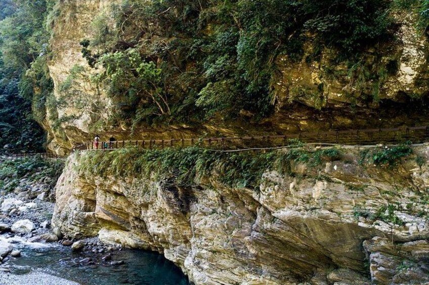 Un puente estrecho sobre un río, rodeado de riscos y vegetación densa. 2
