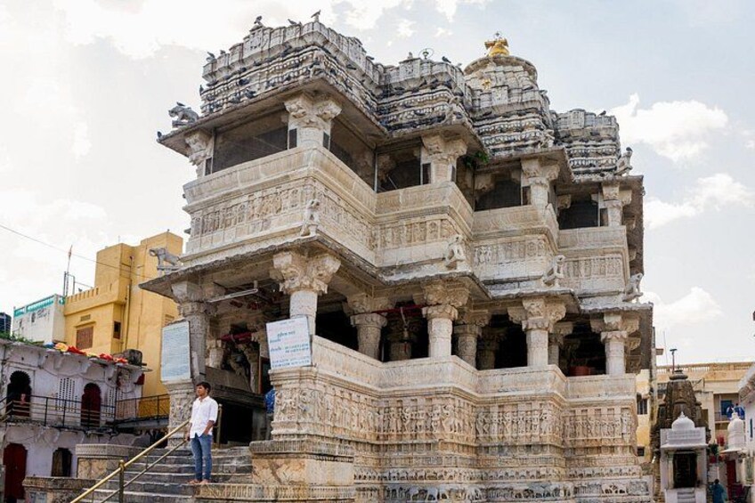 A multi-tiered temple with intricate carvings and a person standing on the steps. 3