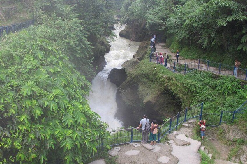 A waterfall, a bridge, and people observing the scenery. 3