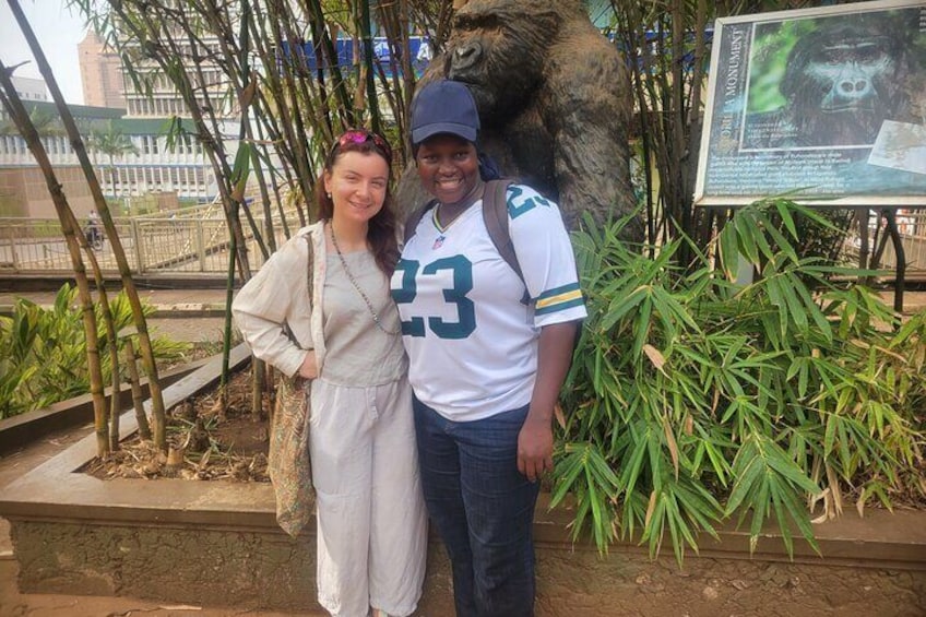 Two people standing in front of a gorilla statue and a sign. 5