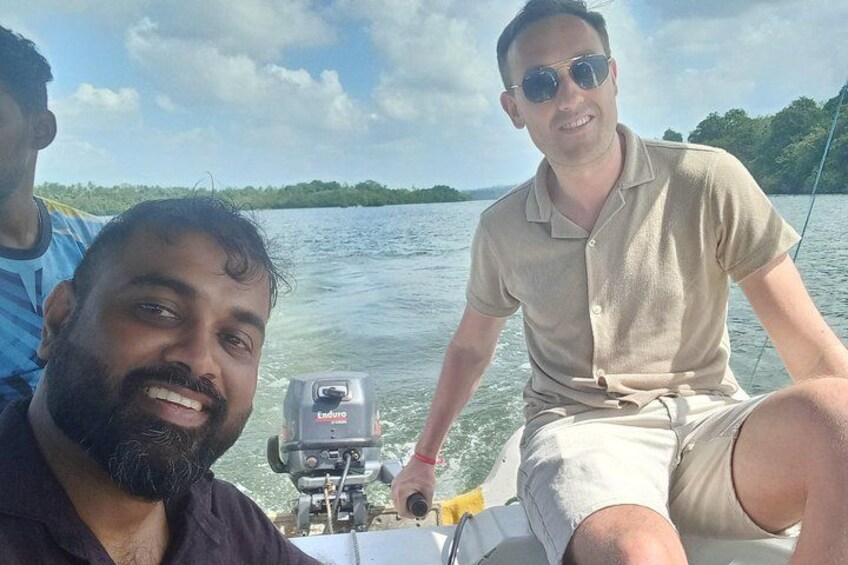 Three people on a boat with a motor, water, and greenery in the background. 3