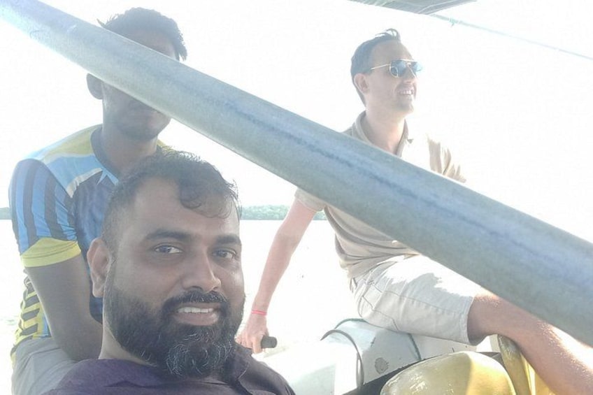 A group of people on a boat with a metal railing in the foreground. 5