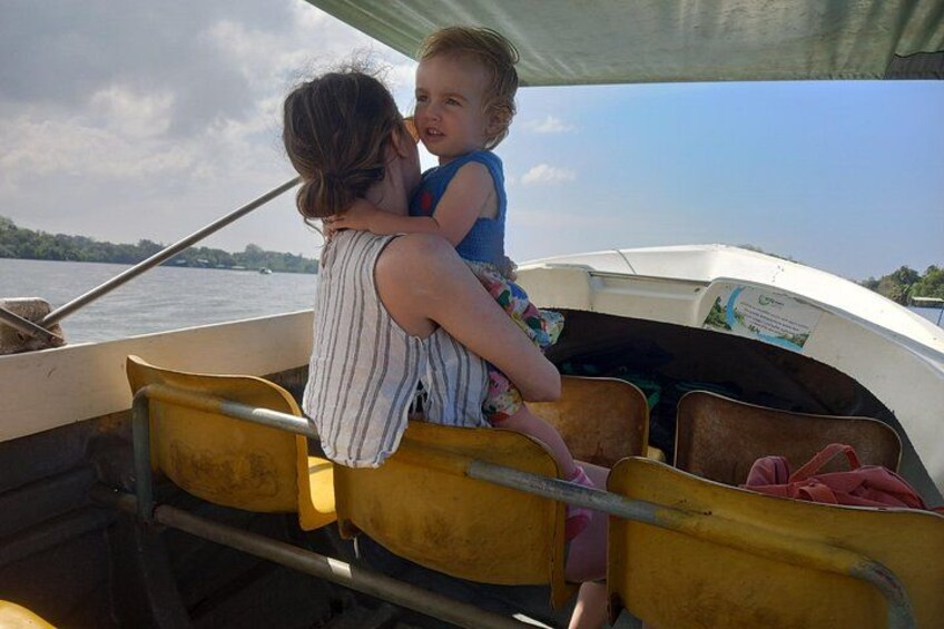A boat with yellow seats and a person holding a child. 4