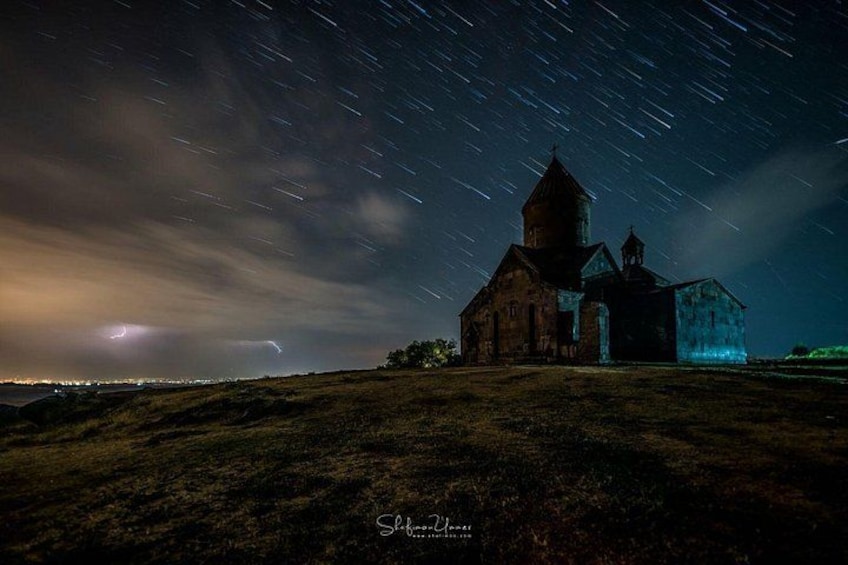 En kyrka med ett klocktorn under en stjärnklar natthimmel. 2