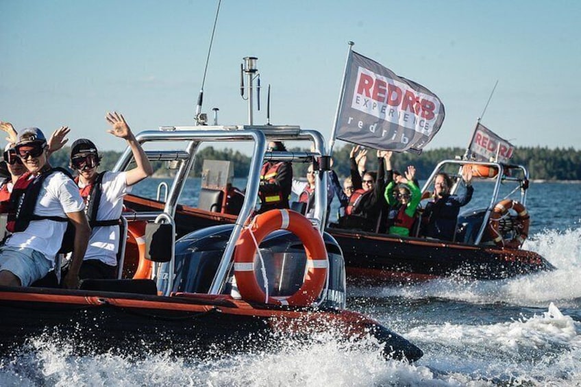 Two boats with people on them, one with a flag that reads 'REDRB EXPERIENCE'. 2