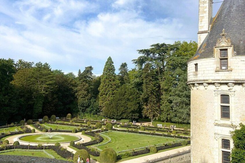 Ein historisches Gebäude mit einem kreisförmigen Garten und hohen Bäumen. 5