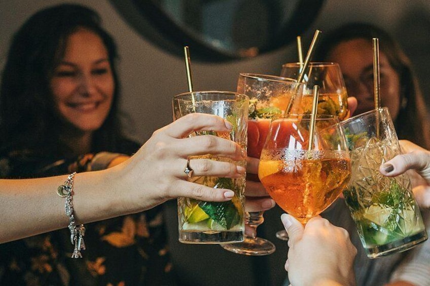 A group of people toasting with drinks in glasses. 4
