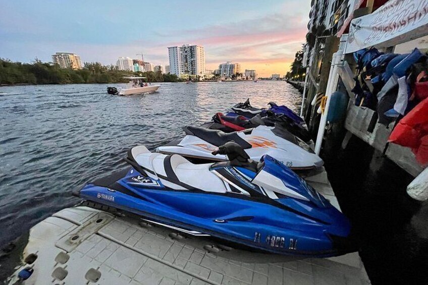 A jet ski docked at a pier with a city skyline in the background. 4