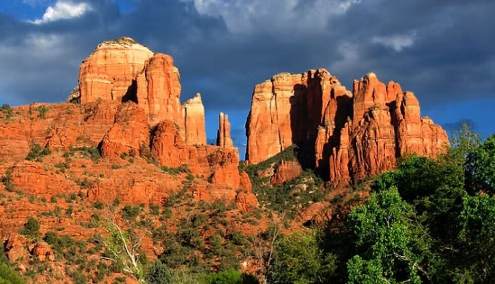 Ett ökenlandskap med markanta röda klippformationer och gles vegetation. 3