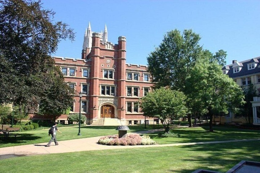 A large red brick building with a tower, surrounded by well-maintained lawns and trees. 4