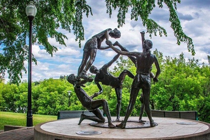 Une sculpture représentant quatre personnages dans un parc. 3