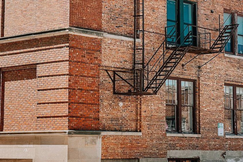 A brick building with a fire escape and windows. 3