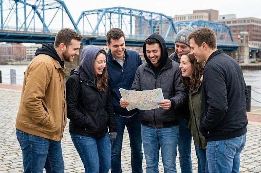 Un groupe de personnes se tient sur un chemin pavé de pierres, et observe une carte. 1