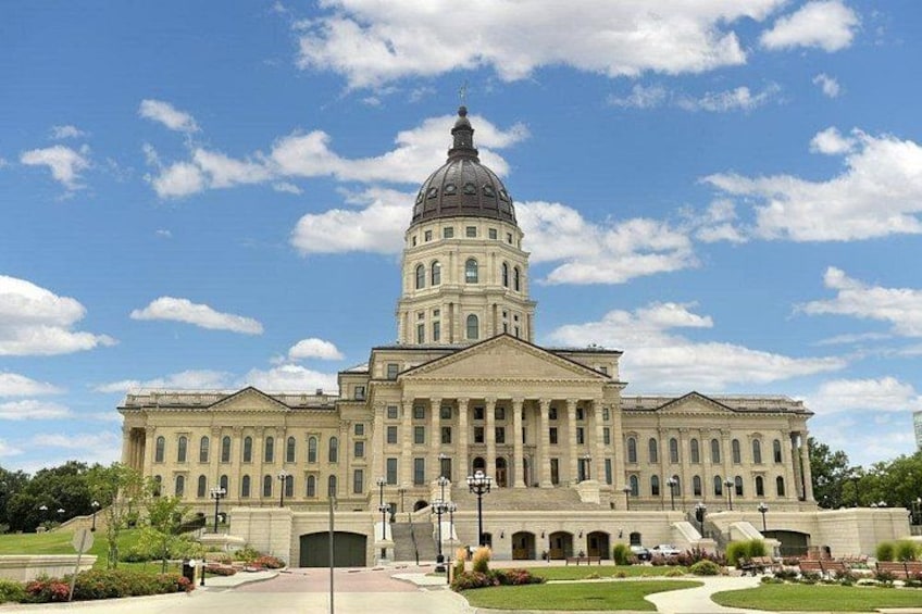 A large neoclassical building with a prominent dome, symmetrical facade, and a central entrance. 3