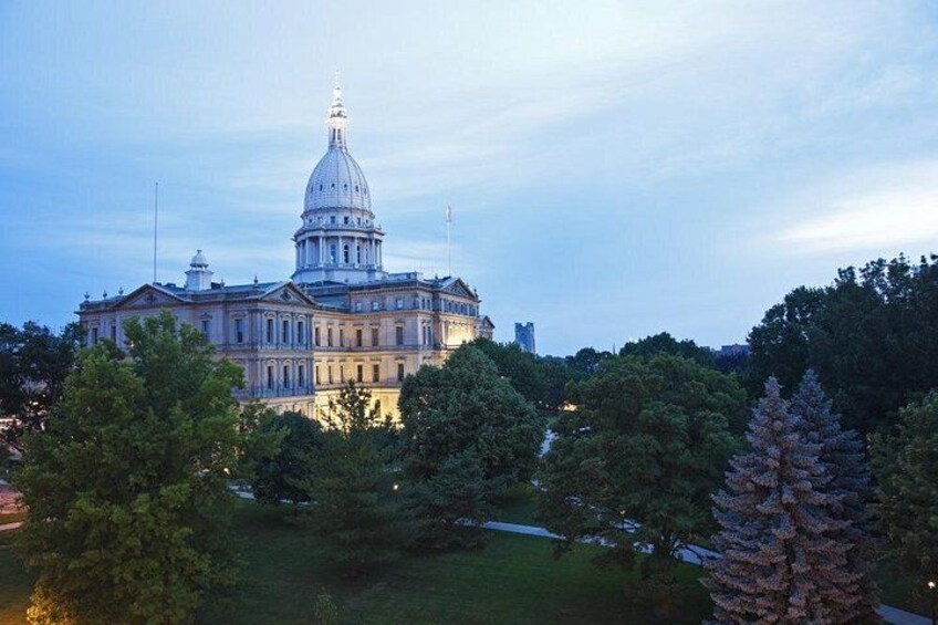A large government building with a prominent dome, surrounded by trees and grass. 3