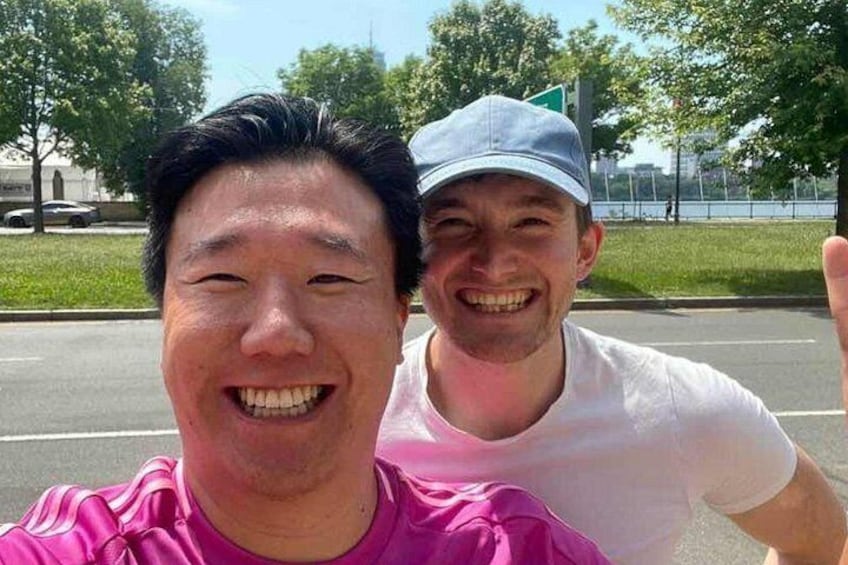 Dos personas tomándose un selfie con una carretera y follaje al fondo. 3