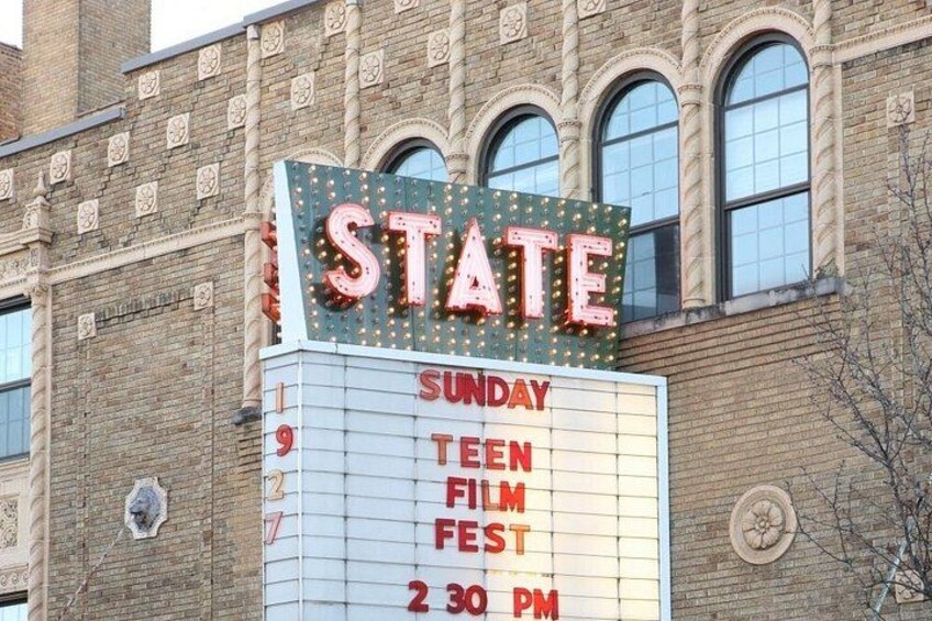 A theater marquee with the word 'STATE' and a schedule for a 'Teen Film Fest' on Sunday at 2:30 PM. 5
