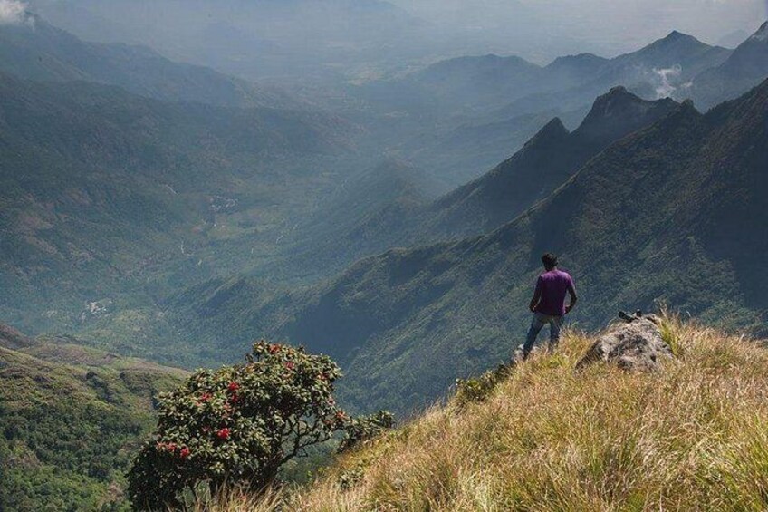 A person standing on a mountain ridge overlooking a valley. 4