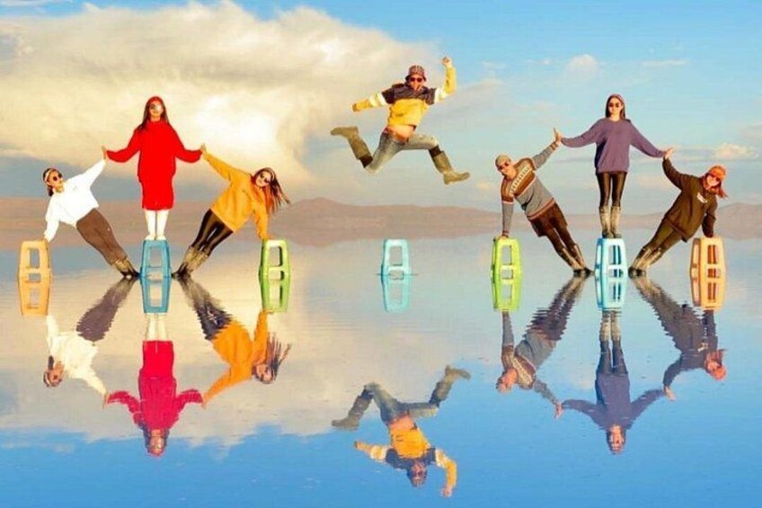 Des personnes pratiquent le hoverboard au-dessus d’une surface d’eau qui reflète l’image, avec des montagnes en arrière-plan. 2