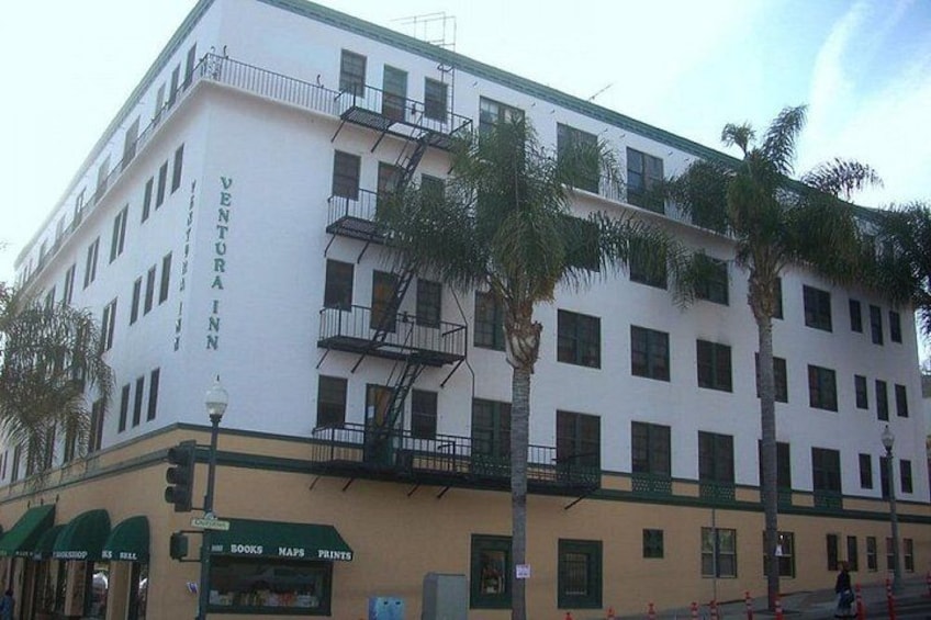 A white building with the sign 'VENTURA INN' and a storefront with signs for 'BOOKS,' 'MAPS,' and 'PRINTS.' 2