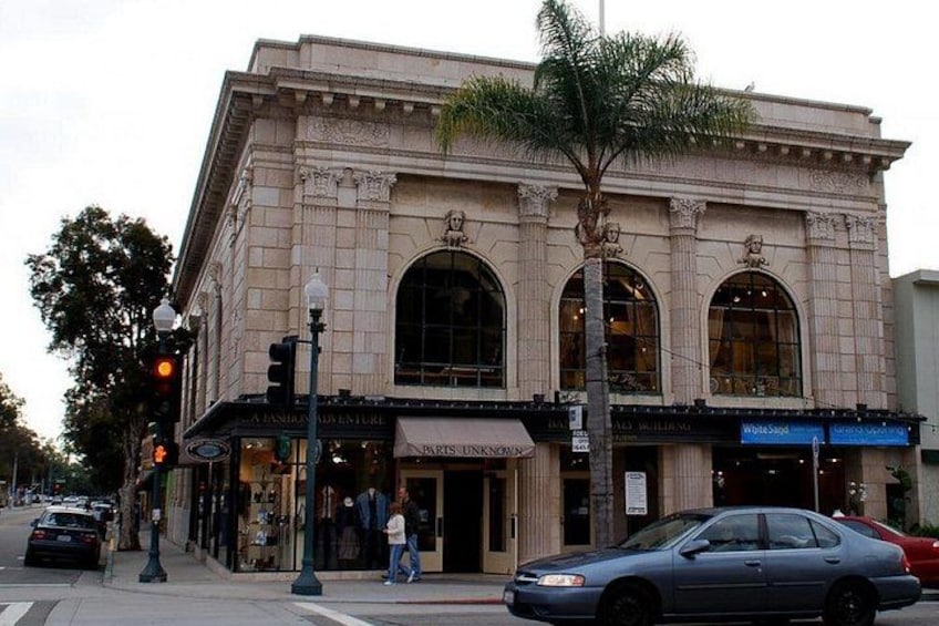 A historic building with arched windows and a palm tree in front. 3