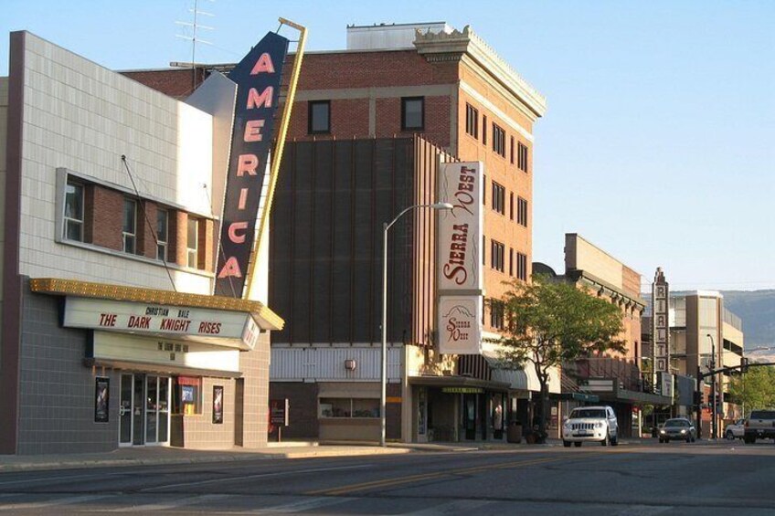 A theater with a marquee reading 'AMERICA' and 'THE DARK KNIGHT RISES' playing. 5