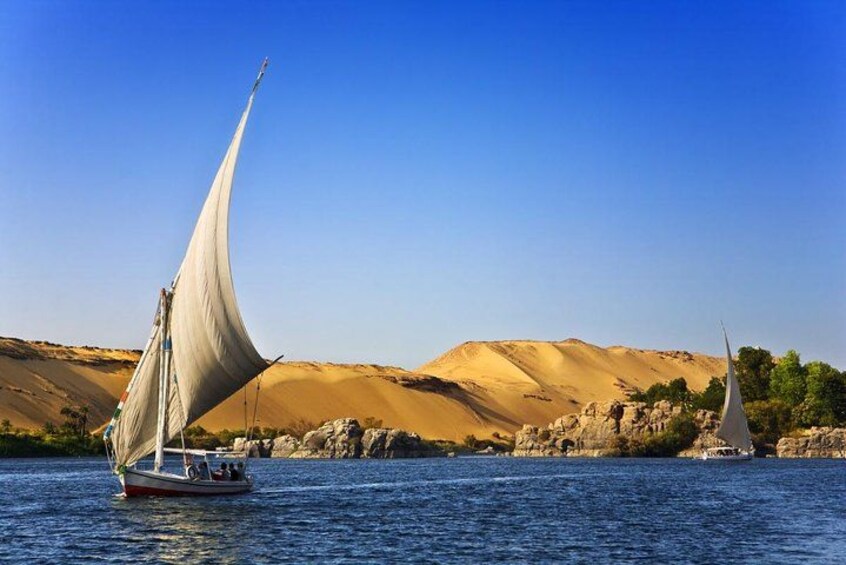 Un velero en un río tranquilo con un paisaje desértico al fondo. 2