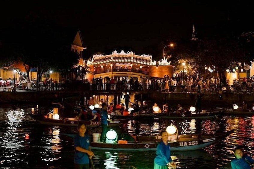 A nighttime river scene with illuminated boats and a traditional building in the background. 2