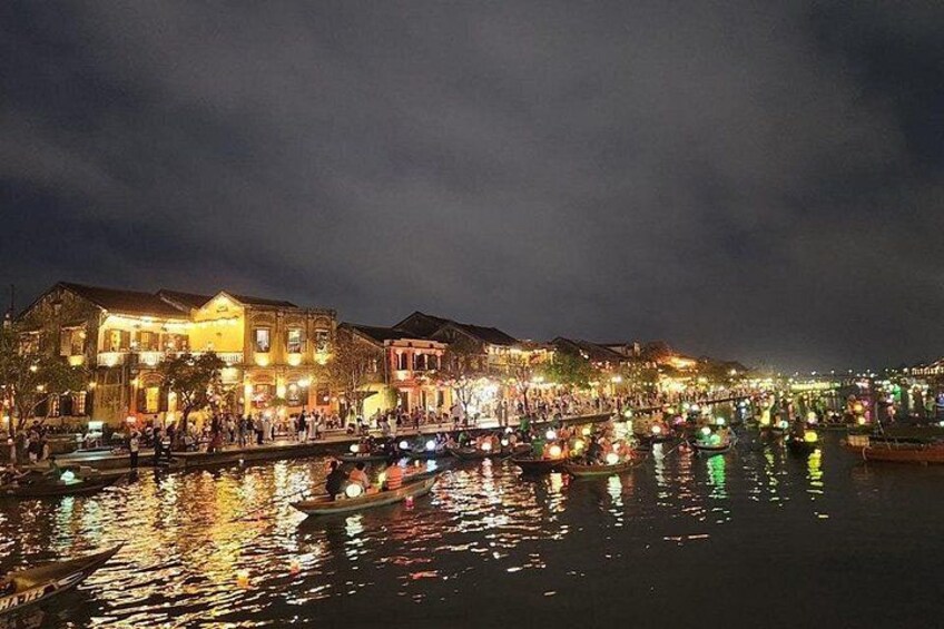 A river with boats and illuminated buildings along the banks. 5