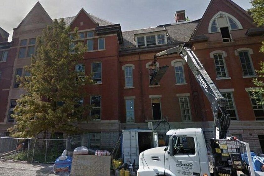 Un edificio de ladrillo grande con una grúa y un camión. 5