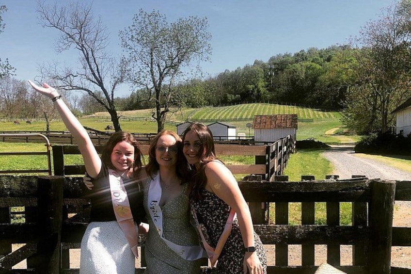 Three people sitting on a bench with a rural landscape in the background. 2
