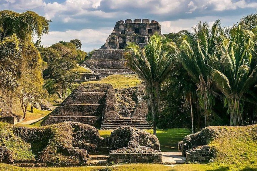 Gamle ruiner med trappeformede pyramider, palmer og en klar himmel. 4