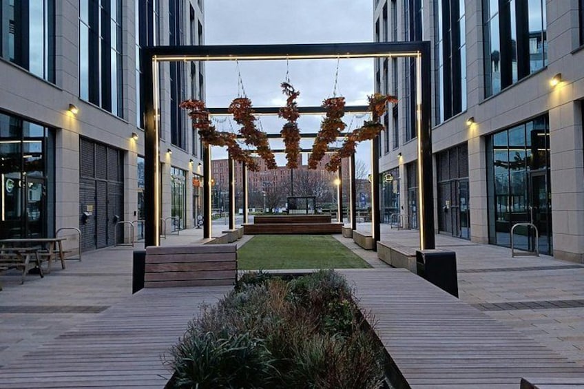 A modern building with a glass facade, a wooden deck, and a central garden area with autumn leaves. 4