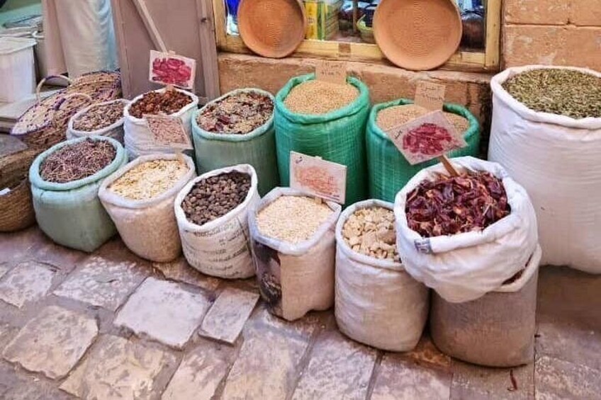 Various sacks of grains and legumes displayed at a market. 4
