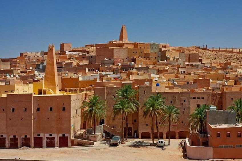 A cityscape with traditional architecture, palm trees, and a prominent minaret. 5