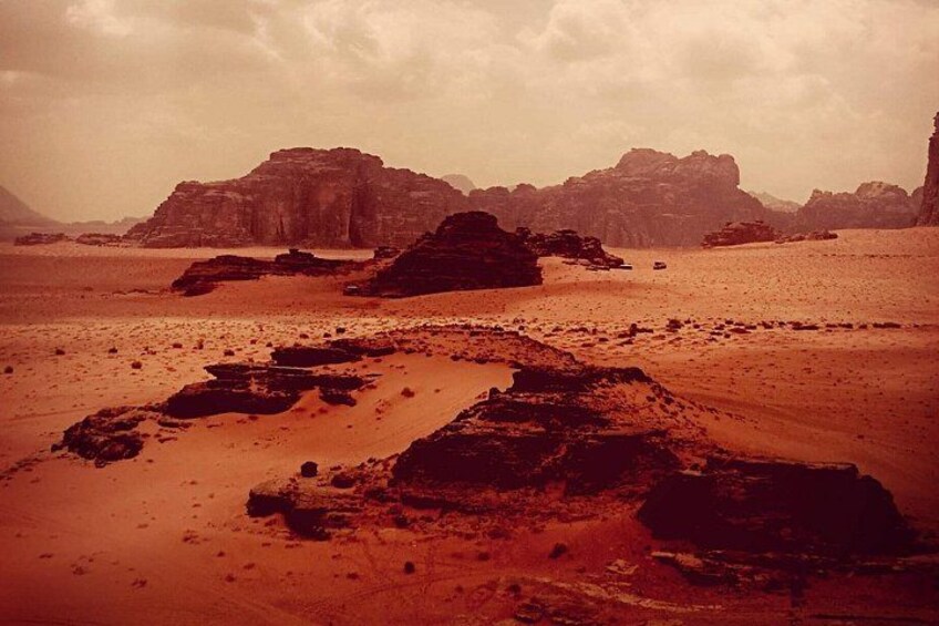 A desert landscape with rocky formations and a cloudy sky. 4