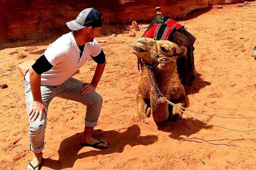 A man with a camel in a desert setting. 1