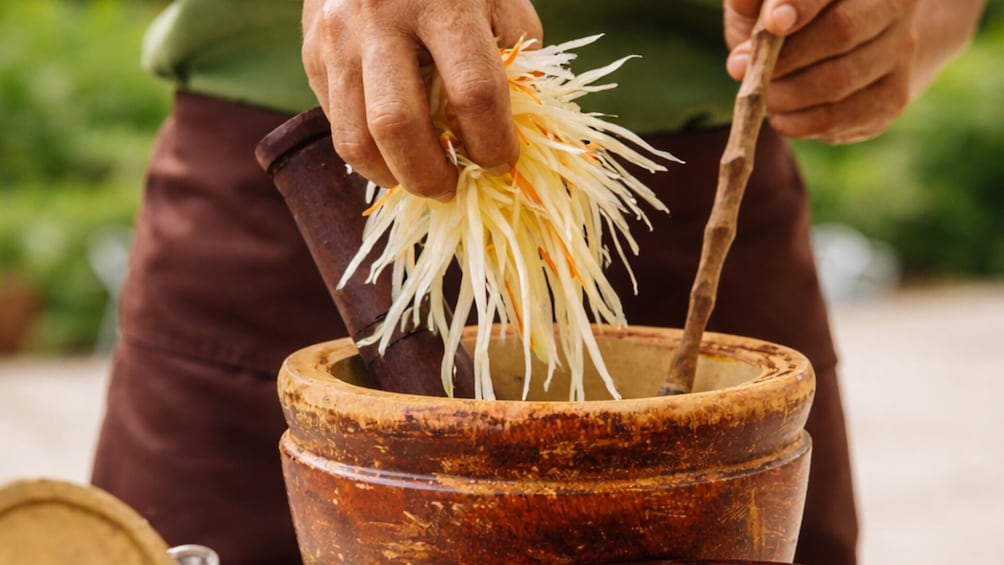 A person peeling a vegetable in a rustic setting. 1
