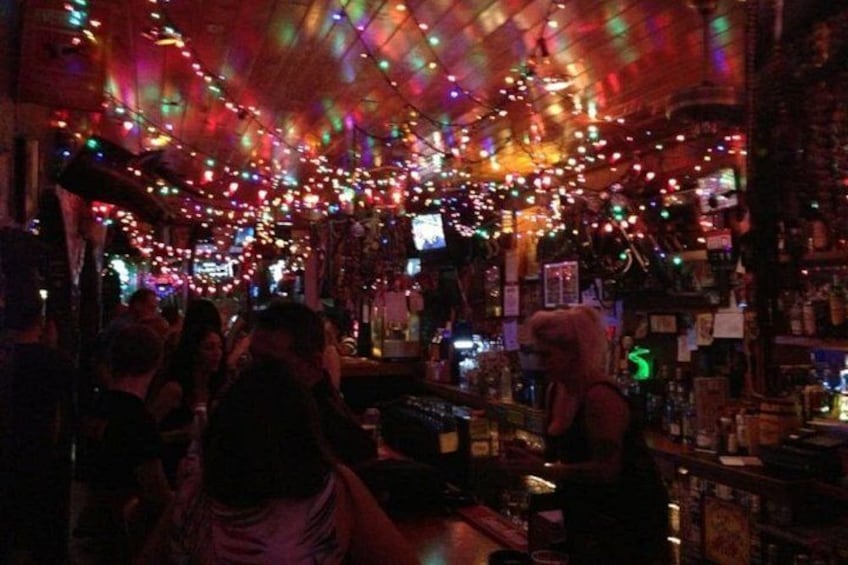 Un bar aux lumières colorées, où il y a du monde. 1