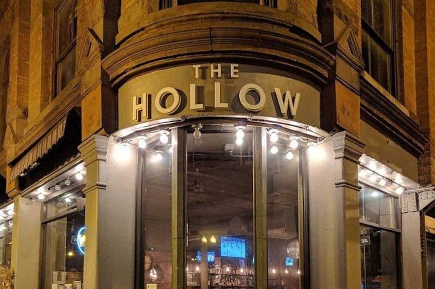 The Hollow building facade at night with illuminated signage and windows. 4
