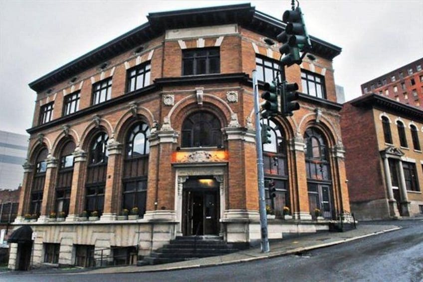 A historic brick building with arched windows and a prominent entrance. 5