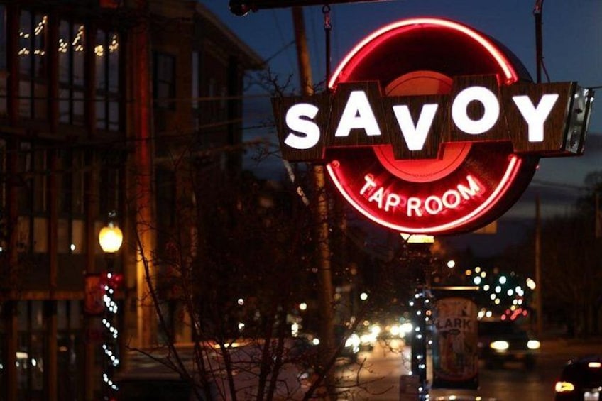 A neon sign for 'SAVOY TAP ROOM' with a circular design and the word 'TAP ROOM' inside. 3