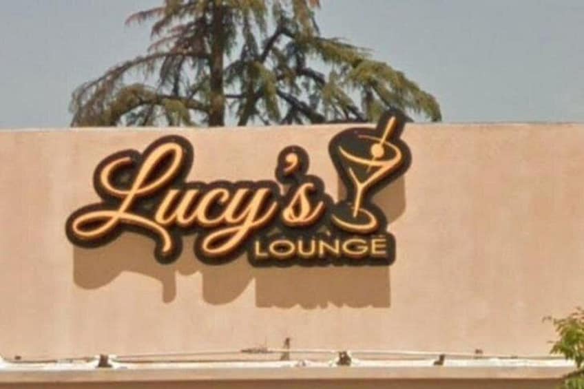 Señal de Lucy's Lounge con una palmera al fondo. 4